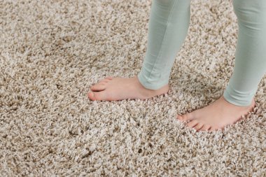 Evdeki yumuşak halıdaki kız, yakın plan. Metin için boşluk