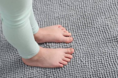 Evdeki yumuşak halıdaki kız, manzaranın üstünde.