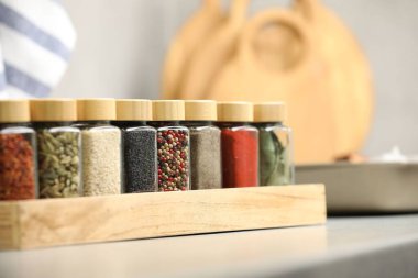 Işık masasındaki kavanozlarda farklı aromatik baharatlar, yakın plan.