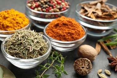 Gri masada farklı aromatik baharatlar, yakın plan.