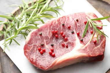 Masanın üstünde çiğ et ve baharat var.