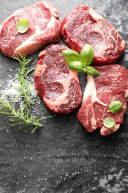 Koyu masa üzerinde çiğ et ve baharat parçaları, düz. Metin için boşluk