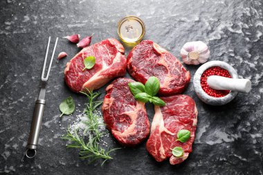 Çiğ et, baharat ve çatal. Koyu masada, düz yerde.