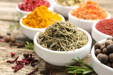 Ahşap masada farklı aromatik baharatlar, yakın plan.