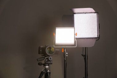 Profesyonel ışıklandırma ekipmanı ve gri arka planda kamera. Metin için boşluk