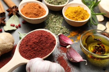 Gri masada farklı baharatlar ve yağ, yakın plan.