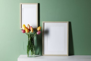 Boş resim çerçeveleri ve güzel laleler.
