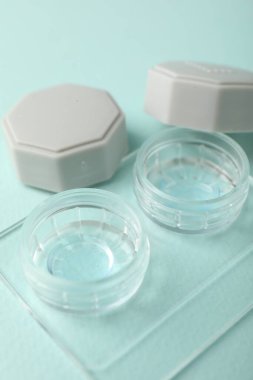 Açık turkuaz arka planda kontak lensleri, yakın plan