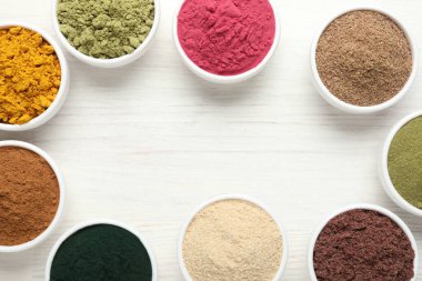 Beyaz ahşap masadaki farklı süper yiyecek tozlarının çerçevesi düz. Metin için boşluk