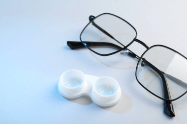 Beyaz arkaplanda kontak lensli ve gözlüklü dosya, yakın plan