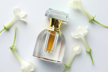 Beyaz arka planda parfüm ve yasemin çiçekleri, düz yatıyordu.