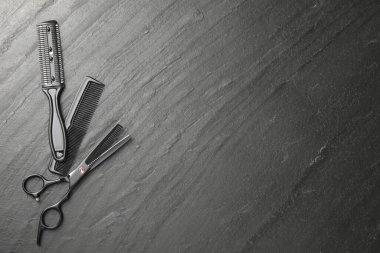 Siyah masada farklı berber aletleri var, düz yerde. Metin için boşluk