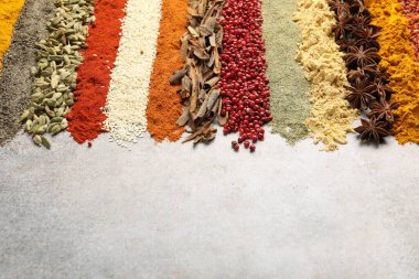 Açık gri masada birçok farklı baharat var, yakın plan. Metin için boşluk