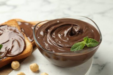 Çikolata, naneli ve fındıklı beyaz mermer masa, yakın plan.