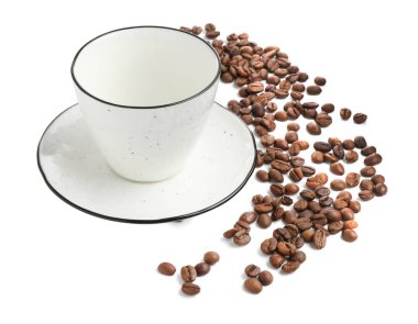 Beyaz üzerine izole edilmiş kavrulmuş kahve çekirdekli seramik fincan.