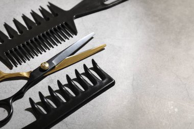 Gri masadaki farklı kuaför aletleri, yakın plan. Metin için boşluk