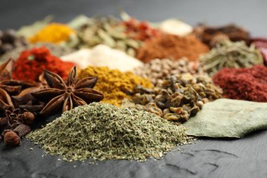 Gri masada farklı aromatik baharatlar, yakın plan.