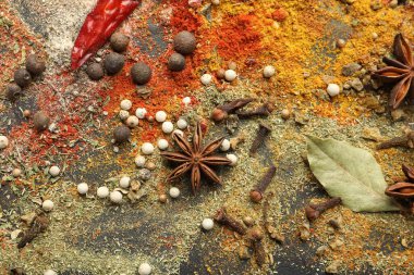 Gri masada farklı aromatik baharatlar, üst görünüm.