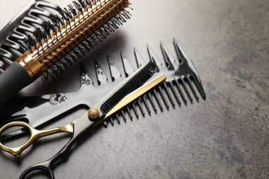 Gri masadaki farklı kuaför aletleri, yakın plan.