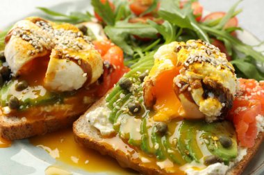 Avokadolu lezzetli sandviçler, haşlanmış yumurta ve somon, yakın plan.