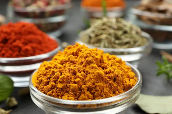 Gri masada farklı aromatik baharatlar, yakın plan.