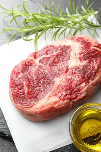 Masanın üzerinde çiğ et, biberiye ve yağ var.