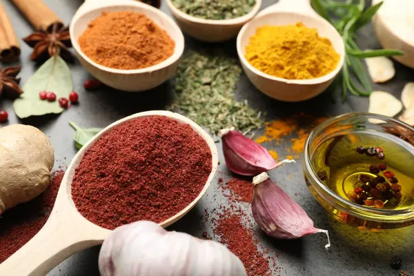 Gri masada farklı baharatlar ve yağ, yakın plan.