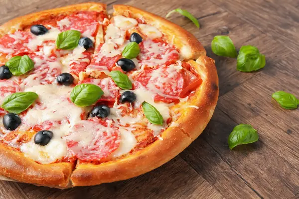 Salamlı, peynirli, fesleğenli ve zeytinli lezzetli pizza.