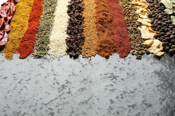 Karanlık masada birçok farklı baharat var, yakın plan. Metin için boşluk