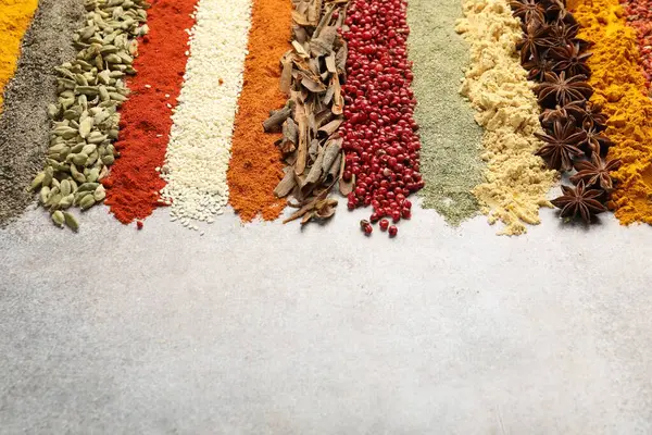 Açık gri masada birçok farklı baharat var, yakın plan. Metin için boşluk