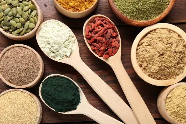 Tahta masadaki farklı süper yiyecekler, düz yatış.