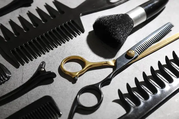Gri masadaki farklı kuaför aletleri, yakın plan.