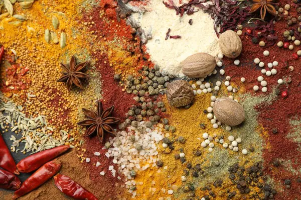 Gri masada farklı aromatik baharatlar, üst görünüm.