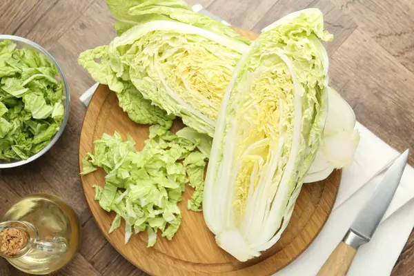 Taze kesilmiş Çin lahanası, yağ ve bıçak ahşap masada, düz yatıyordu.