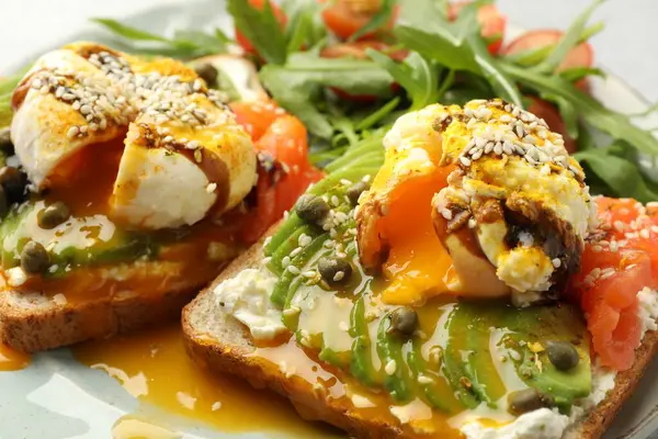 Avokadolu lezzetli sandviçler, haşlanmış yumurta ve somon, yakın plan.