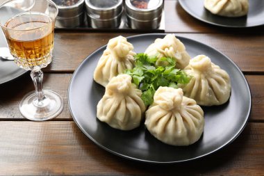 Nefis khinkali kişniş ve şarapla servis edilir ahşap masada, yakın plan.