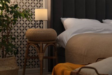 Yan masada yatağın yanında lamba var.