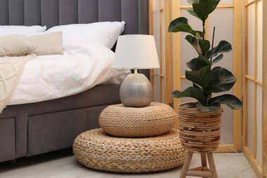 Yan masada yatağın yanında lamba var.