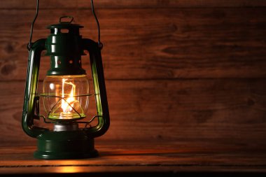 Ahşap masada eski bir gaz lambası, metin için yer var.