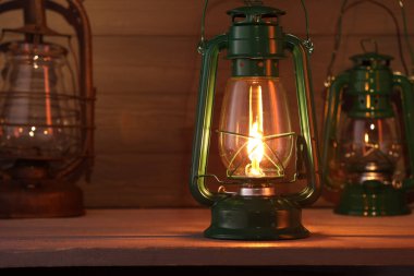 Ahşap masa üzerinde eski gazyağı metal lambalar