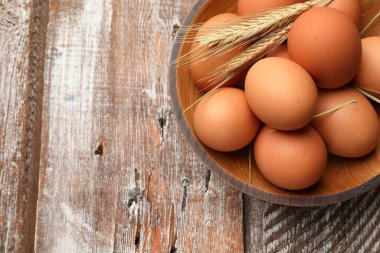 Çiğ yumurta ve çiğ buğday, ahşap masa, üst manzara. Metin için boşluk