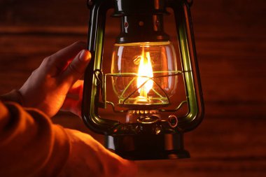 Ahşap arka planda klasik gaz lambası olan adam, yakın plan.