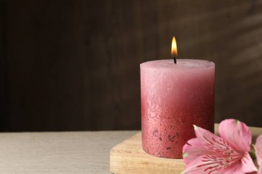 Masada yanan mum ve zambak çiçekleri, yakın plan. Metin için boşluk