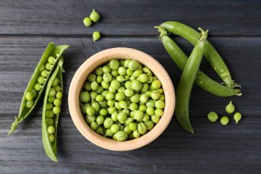 Taze taze bezelyeler siyah ahşap masada, düz yatıyordu.