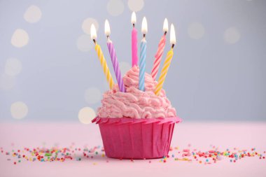 Kekin içinde mum yakmak ve bulanık ışıklara karşı masaya serpiştirmek.