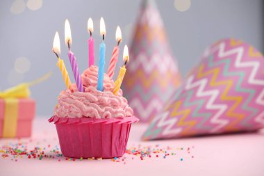 Kekin içinde mum yakmak, fıskiyeler ve bulanık ışıklara karşı parti dekorasyonu.