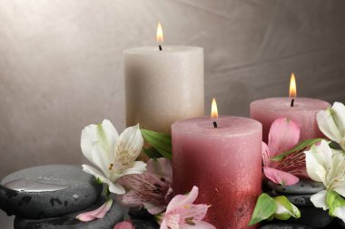 Yakıcı mumlar ve güzel çiçekler arka planda, yakın plan