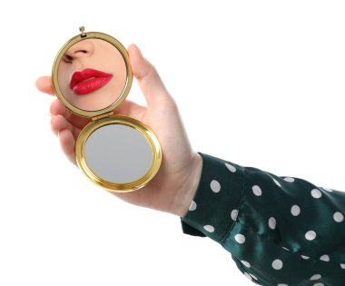 Kırmızı dudaklı güzel kadın beyaz arka planda aynaya bakıyor, yakın plan.