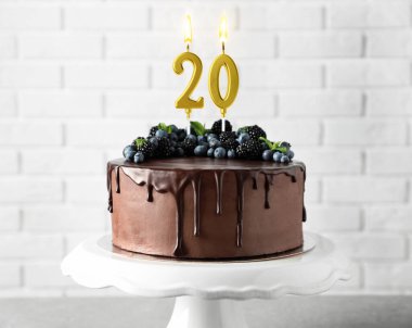 Meyveli ve yanan mumlu çikolatalı kek. 20. yaş günü ya da diğer özel günler