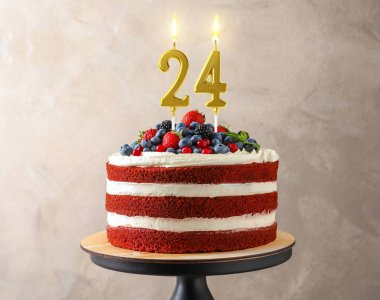 Böğürtlenli lezzetli pasta ve bej arka planda yanan mumlar. 24 'üncü yaş günü veya diğer özel günler